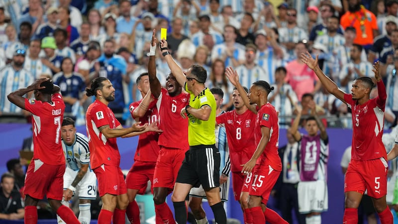 Los jugadores de Suiza discuten con el árbitro portugués Joao Pinheiro, quien muestra una...