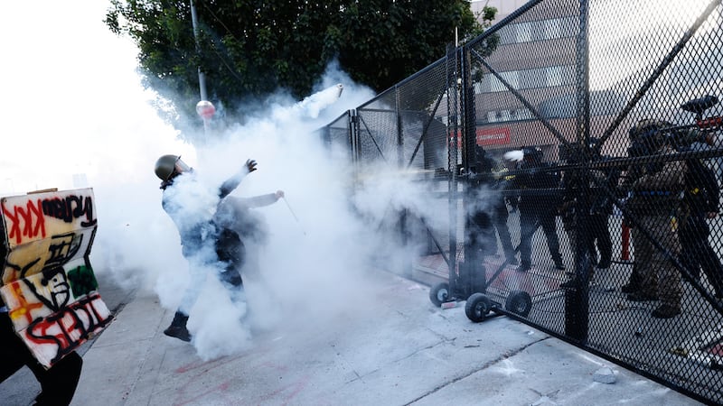 La policía lanza gas lacrimógeno contra manifestantes frente al Centro de Detención...
